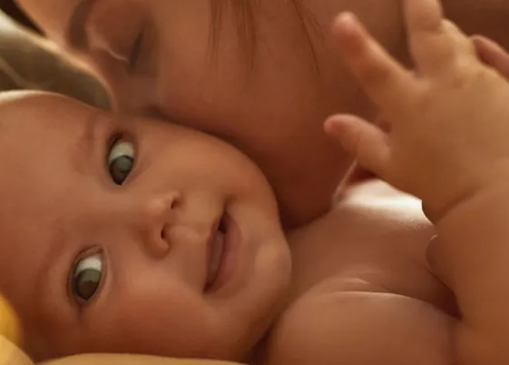 Bebê sorrindo no colo da mãe