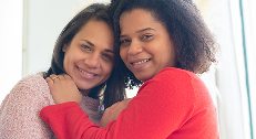 Casal de mulheres abraçado e sorrindo